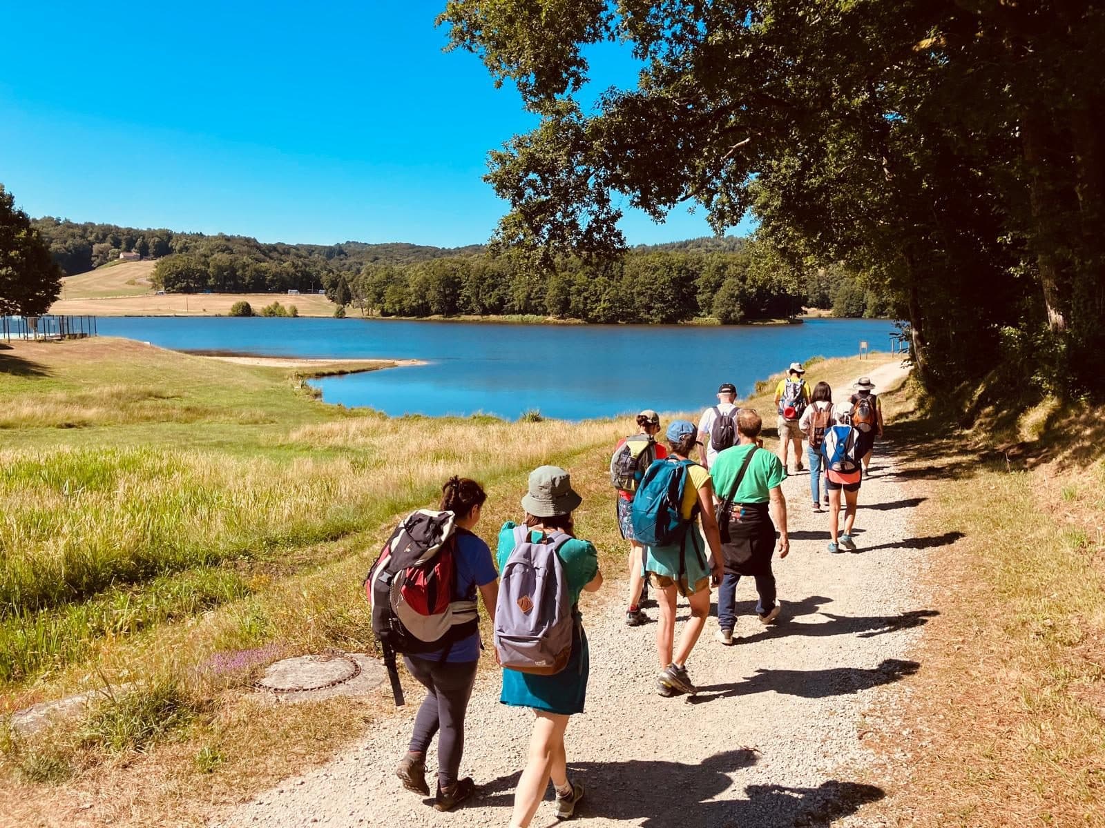 Randonneurs en file indienne au bord d'un lac turquoise